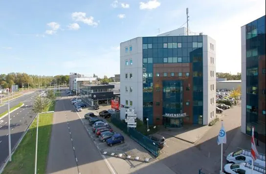 Kantoorpand Havenstate aan de Waalhaven in Rotterdam met parkeerplaatsen en omliggende gebouwen.